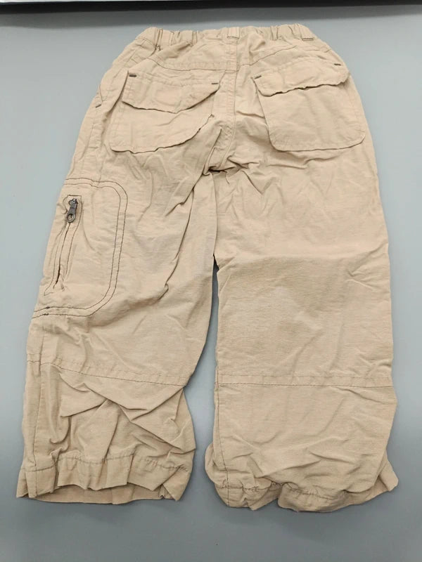 Rückseite der beigen Kinderhose mit Gesäßtaschen und Reißverschlusstasche am Bein