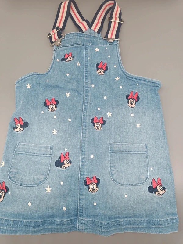 Detailansicht des hellblauen Trägerrocks mit Minnie-Mouse-Motiven und Taschen