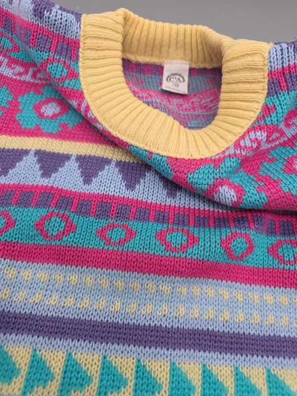 Detail des bunten Strickmusters und gelben Rundhalsausschnitts