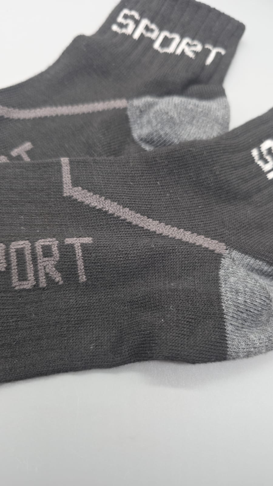 Detail der grauen Ferse und des SPORT-Schriftzugs