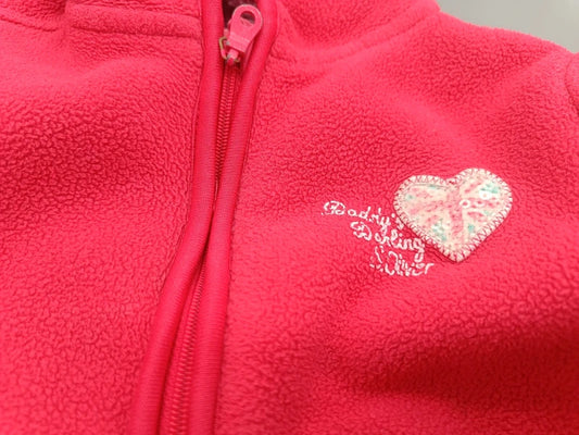 Detailansicht der pinkfarbenen Kinder-Fleecejacke mit Reißverschluss und Herzmotiv in Größe 98