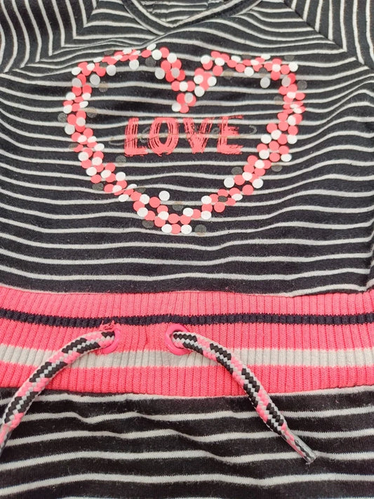 Detailaufnahme des LOVE-Herzmotivs, pinken Taillenbunds und Kordelzugs am gestreiften Mädchenkleid