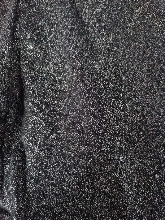 Detailaufnahme der schimmernden Glitzerstruktur der dunkelgrauen Leggings
