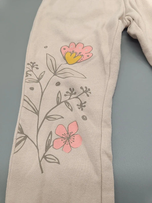 Detailaufnahme des Blumenmotivs auf dem linken Bein der cremefarbenen Mädchenhose