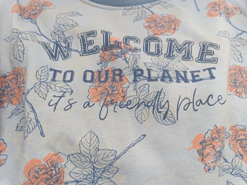 Detail des Blumenmusters und Welcome-to-our-planet-Aufdrucks