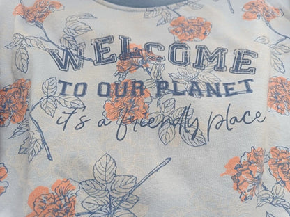 Detail des Blumenmusters und Welcome-to-our-planet-Aufdrucks