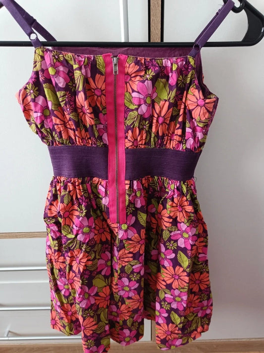 Rückansicht des pink-lila geblümten Mädchen-Jumpsuits mit breitem lilafarbenem Taillenbund in Größe 116