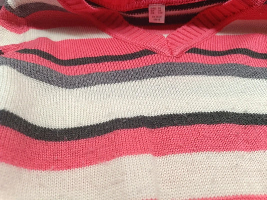 Detailaufnahme des wellenförmigen Strickmusters in Rosa, Grau, Creme und Schwarz