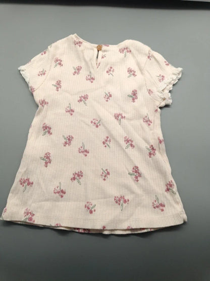 Rückseite des beigefarbenen Blumen-T-Shirts mit Knopf am Ausschnitt