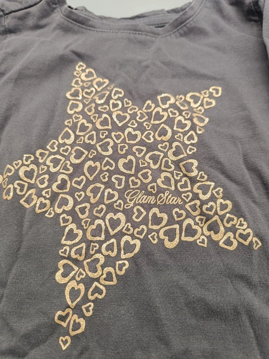Detailaufnahme des goldfarbenen Herzstern-Motivs mit Glam-Stars-Schriftzug auf dem grauen Mädchen-Langarmshirt in Größe 98