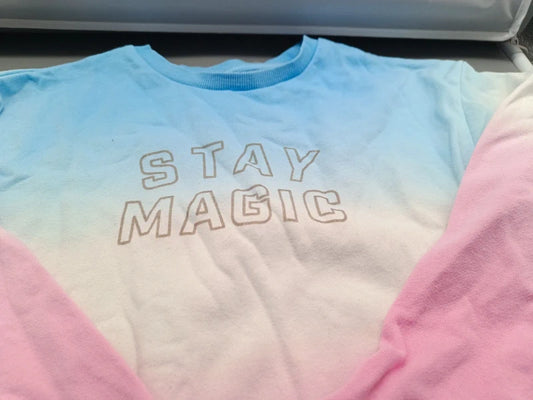 Detailaufnahme des Stay-Magic-Schriftzugs auf dem pastellfarbenen Kinder-Overall in Größe 134