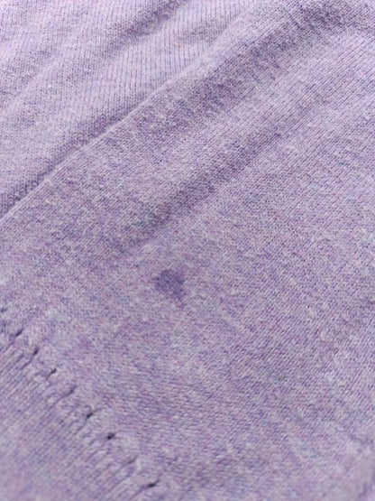Detailaufnahme des kleinen Flecks an einem Ärmel des fliederfarbenen Pullovers