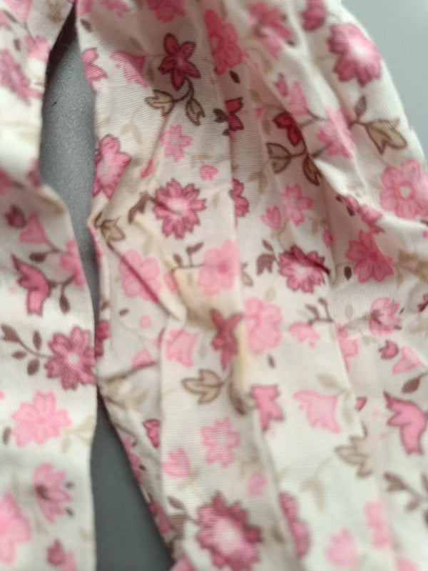 Detailaufnahme vom unteren Ärmel der geblümten Okay Bluse mit angegebenem kleinen Fleck
