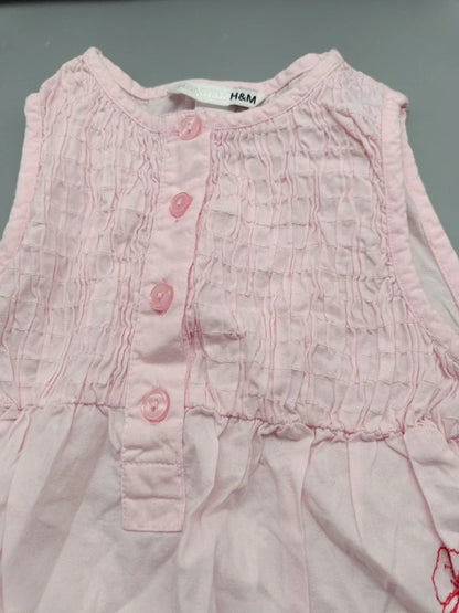 Detail des strukturierten Oberteils und der Knopfleiste des H&M Kinderkleids