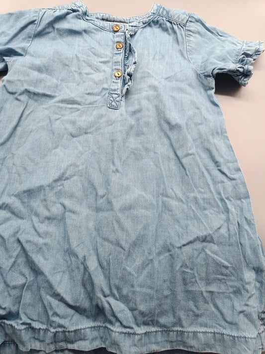 Detailaufnahme der dekorativen Knopfleiste am hellblauen Mädchenkleid mit Rüschenärmeln in Größe 86