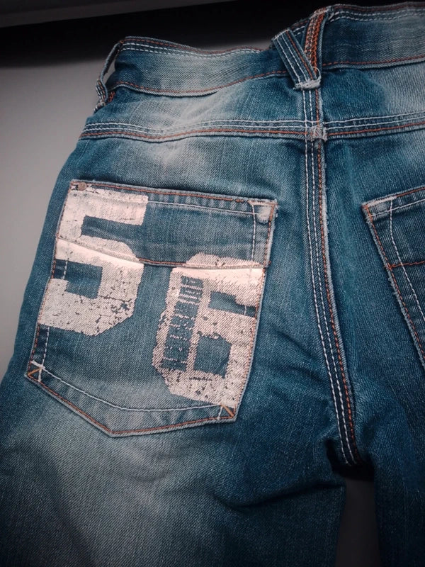 Detailaufnahme des großen 56-Patches auf der Gesäßtasche der blauen Kinderjeans in Größe 122