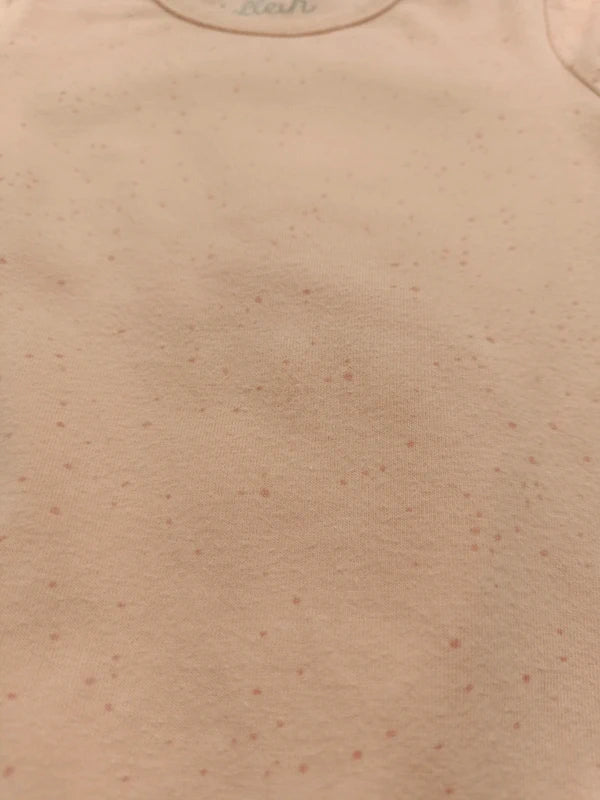Detail des feinen Pünktchenmusters auf dem apricotfarbenen Jollein Schlafanzug