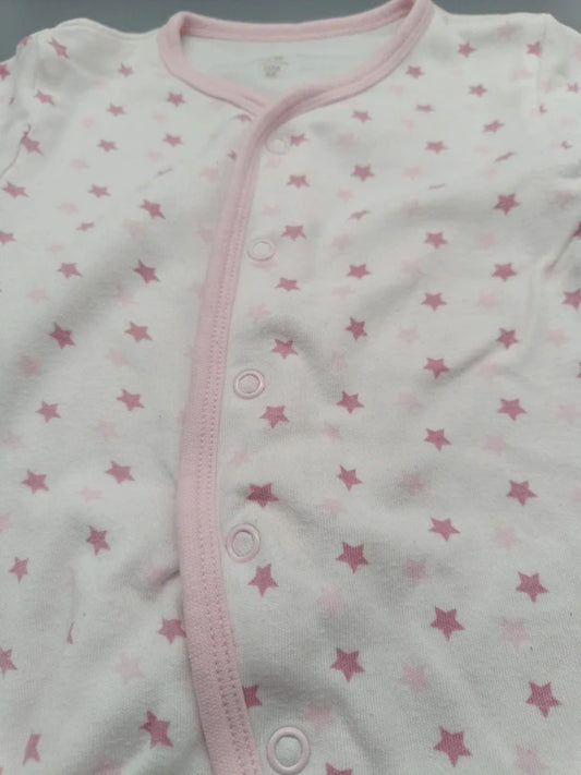 Detail der rosa Sterne und Druckknöpfe des Care Baby-Schlafanzugs