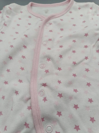 Detail der rosa Sterne und Druckknöpfe des Care Baby-Schlafanzugs