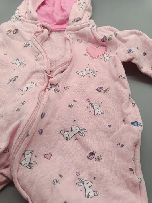 Detailaufnahme des Hasen- und Herzchenmusters auf dem rosa Baby-Overall in Größe 56