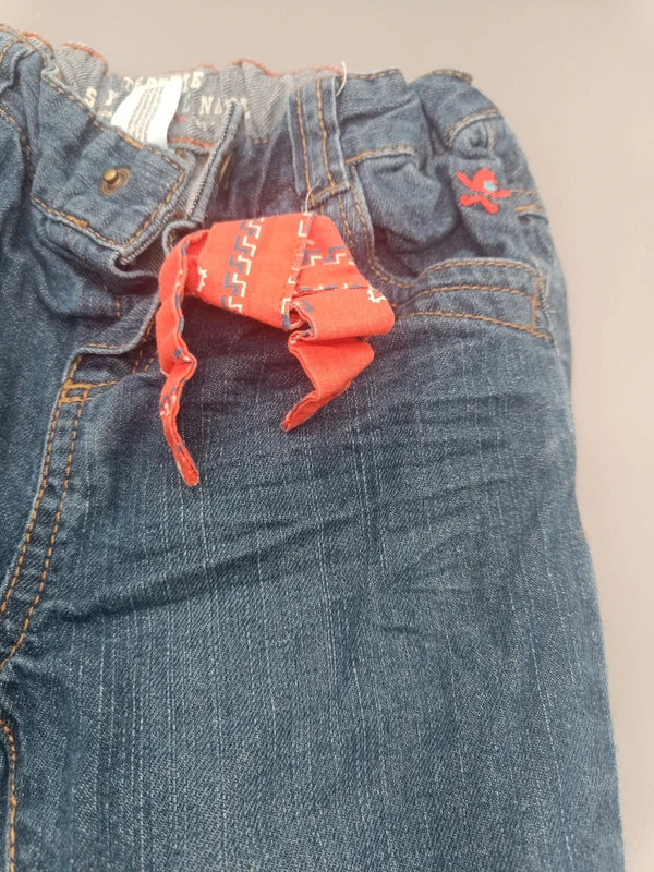 Detail der Taschen und des orangefarbenen Stoffdetails an der Baby Club Jeans