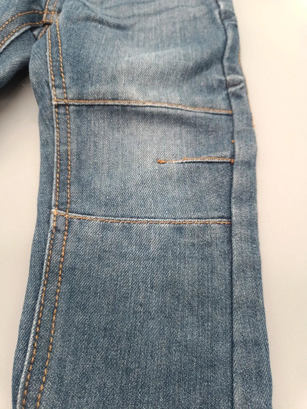 Detail des Jeansstoffs und der Nähte am Hosenbein
