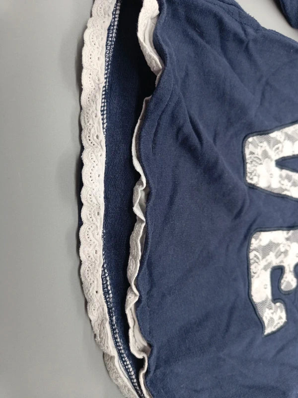 Detail des hellen Spitzenbesatzes am Saum des Topolino Pullovers