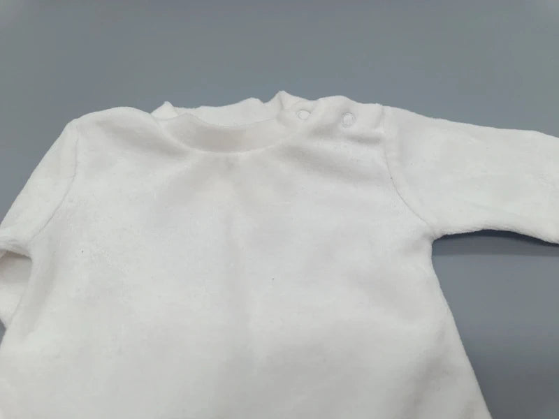 Detail des runden Ausschnitts und Schulterbereichs am weißen Baby-Pullover