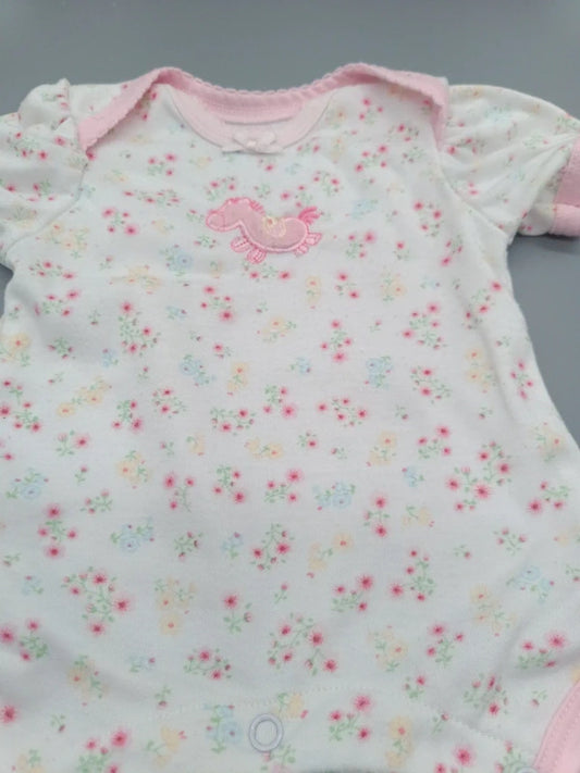 Detail des kleinen rosa Pony-Motivs und Blumendrucks auf dem Babybody