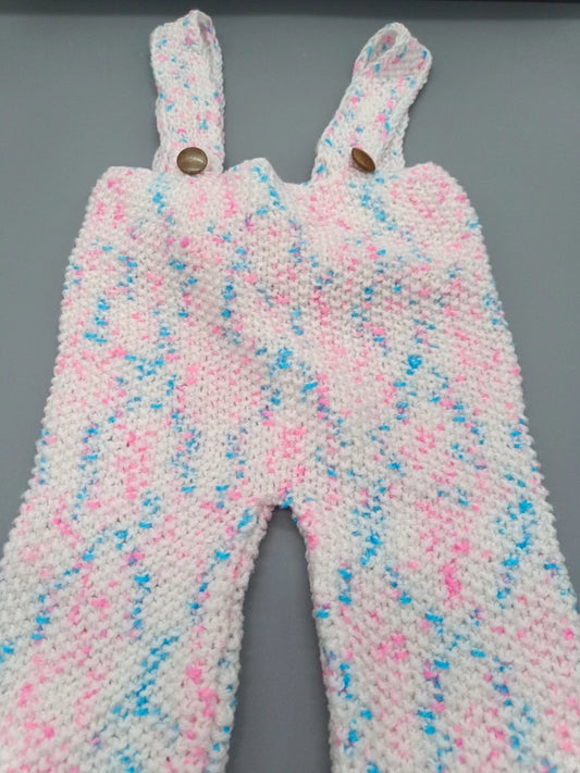 Detailaufnahme der flauschigen rosa-weiß-blauen Baby-Latzhose mit verstellbaren Trägern