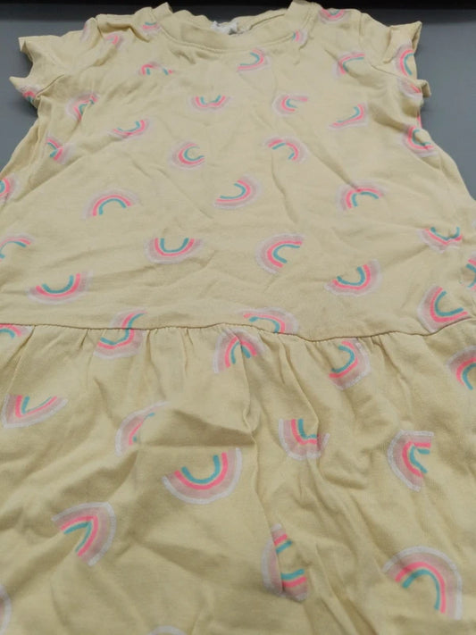 Detailaufnahme der bunten Regenbogen-Motive auf dem cremefarbenen Kinderkleid