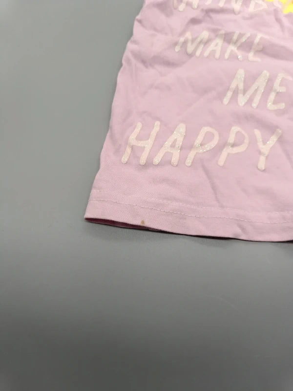 Nahaufnahme des hellen Schriftzugs am Saum des Regenbogen-Shirts