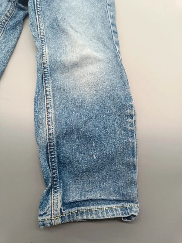 Detail des hellblauen Denim-Hosenbeins und Saums