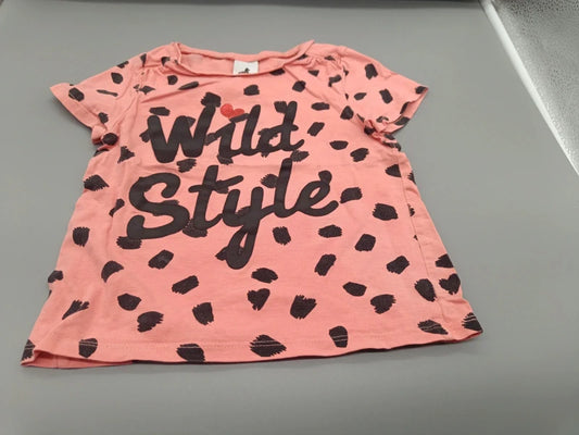 Detailaufnahme des schwarzen Wild-Style-Schriftzugs auf dem roséfarbenen T-Shirt