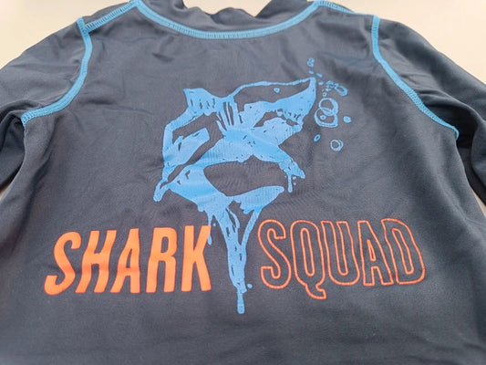 Detail des blauen Hais und orangefarbenen Shark Squad Schriftzugs