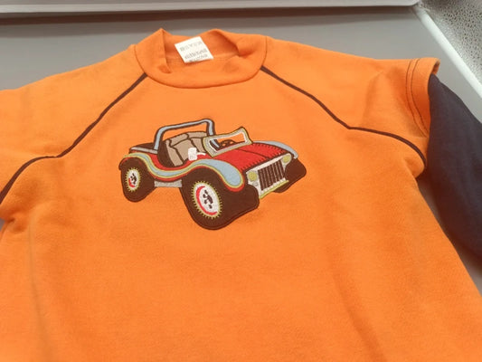 Detail des bunten Autoaufdrucks auf dem orangefarbenen Bambino Pullover