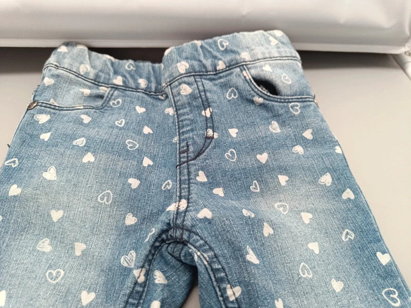 Detail des elastischen Bunds und der vorderen Taschen der Herzchen-Schlupfjeans