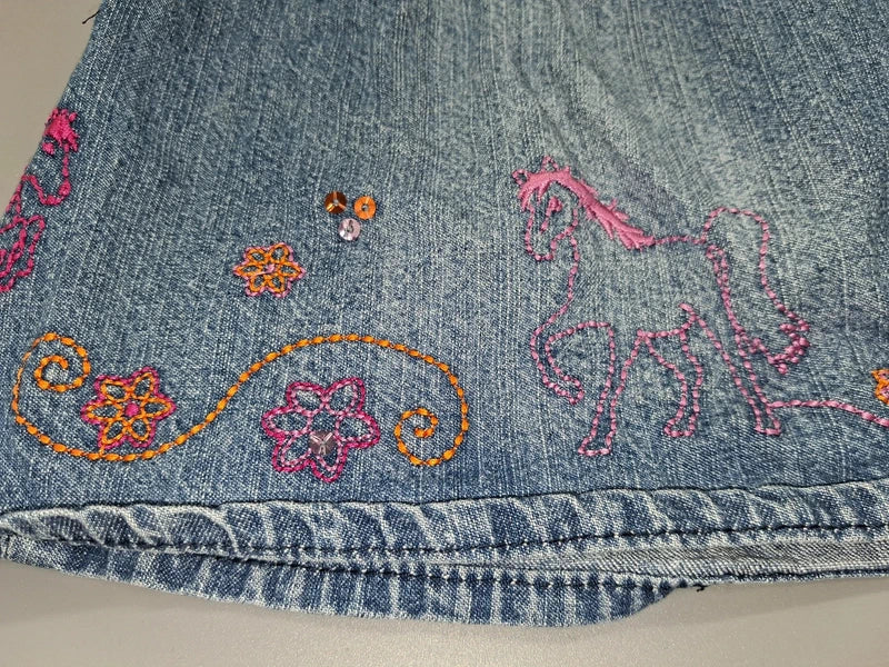 Mädchen Jeansrock Stickerei Pailletten Nahaufnahme Saum
