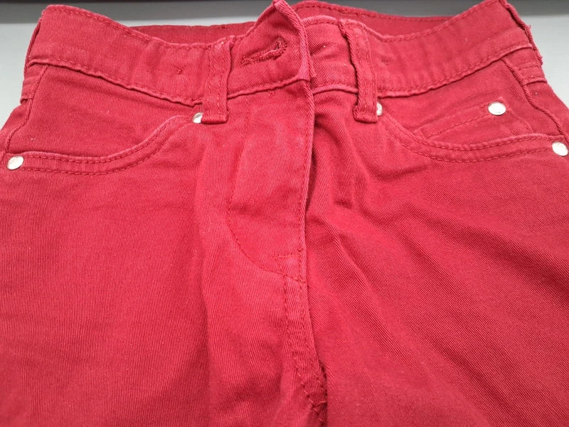 Detail von Bund, Gürtelschlaufen und vorderen Taschen der roten Jeans