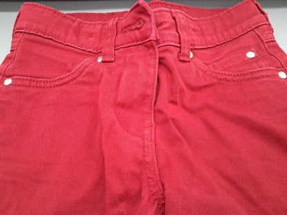 Detail von Bund, Gürtelschlaufen und vorderen Taschen der roten Jeans