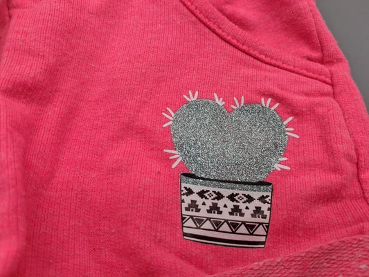 Detail des glitzernden Kaktus-Aufdrucks auf den pinken Shorts
