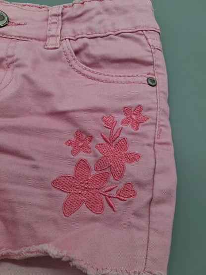 Detail der Blumenstickerei und Vordertasche der fliederfarbenen Shorts