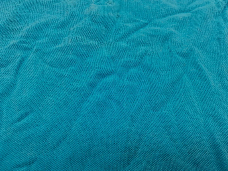 Detail der Stoffstruktur des türkisen Cool Club Poloshirts