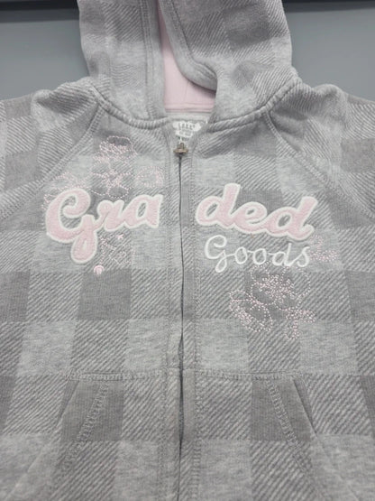 Detail der Schriftzüge, Verzierungen und Taschen der H&M Sweatjacke