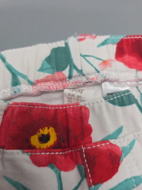 H&M Etikett mit Größe 80 und Detail des Blumenmusters
