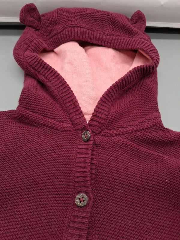 Detail der Öhrchenkapuze mit rosafarbenem Innenstoff und Knopfleiste