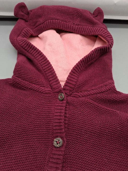 Detail der Öhrchenkapuze mit rosafarbenem Innenstoff und Knopfleiste