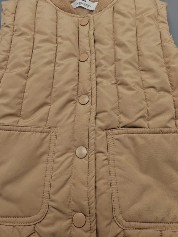 Druckknöpfe und aufgesetzte Taschen der H&M Steppweste