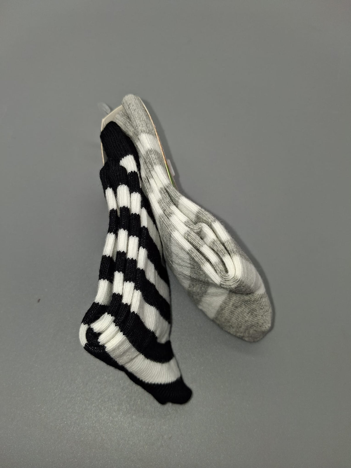 Grau-weißes und schwarz-weißes Streifenmuster der Kindersocken
